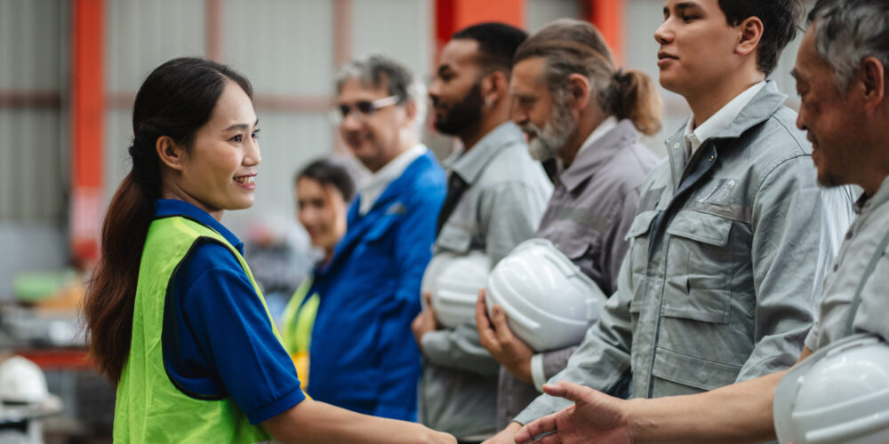 Team engineers and foreman stack hand and shake hands to show success at factory machines. Worker industry join hand for collaboration.